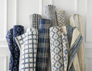 Stack of rugs showing various blue, white, and gray patterns