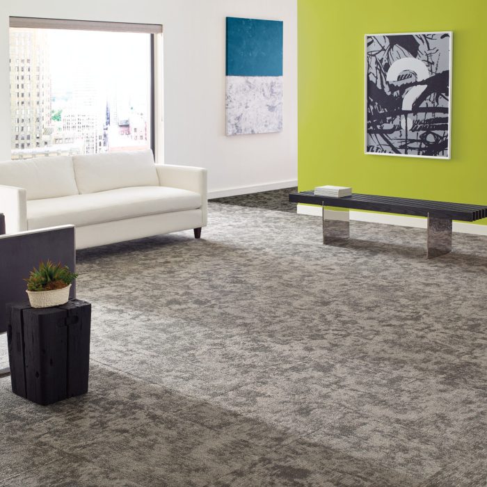 Waiting room with a green statement wall and gray marbled carpet
