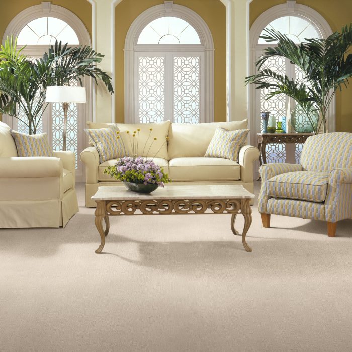 Living room with ivory couches and chairs and a beige carpet