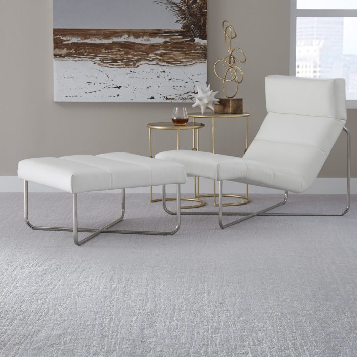 White lounge chair with white plush carpet underneath