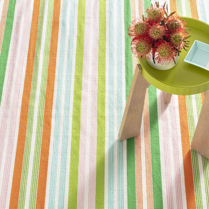 Green, light pink, light blue, and orange striped rug by Albert & Dash
